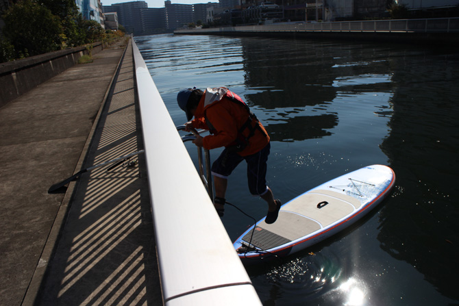 SUPを水面に浮かべ乗り込む